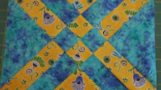 A finished 11 1/2" quilt block in two contrasting colors (blue and yellow) for a two color quilt