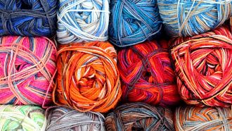 Three rows of multicolored balls of yarn