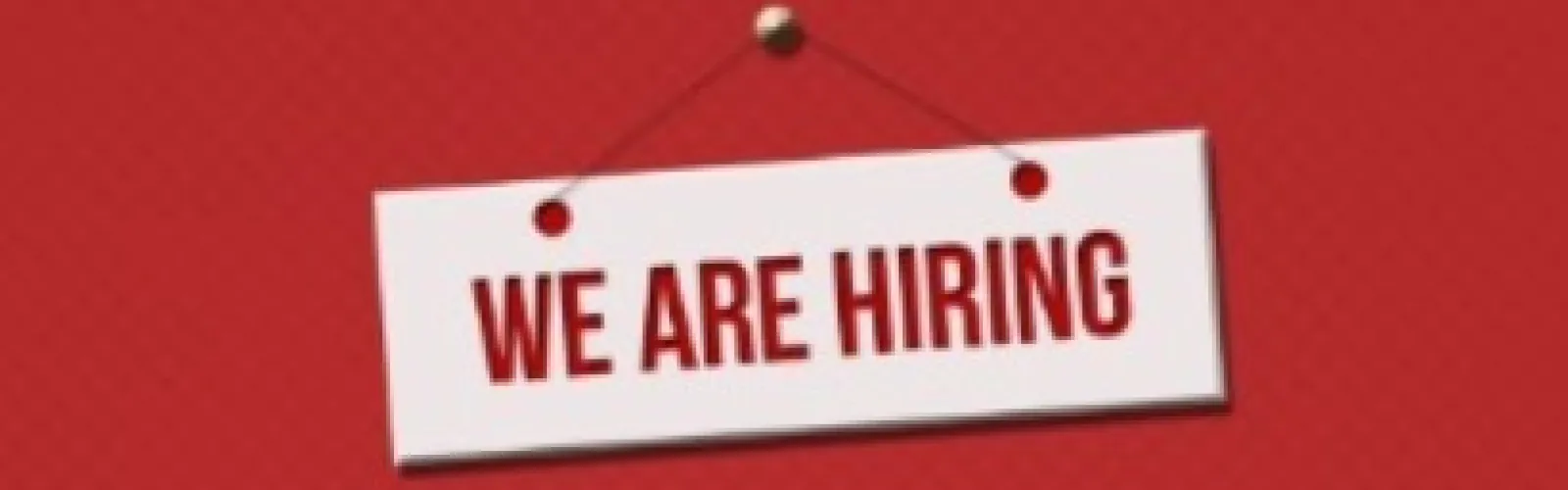 White sign reading "we are hiring" on a red background